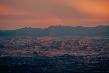 Silhouetted Desert Formations Against a Bright Orange and Pink Sunset Sky in Canyonlands National Park