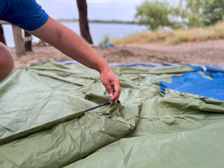Man setting up camping tent for outdoor recreation