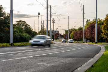 Urban Road With Cars Trees And Overhead Tram Wires During Evening Traffic In Modern City Infrastructure