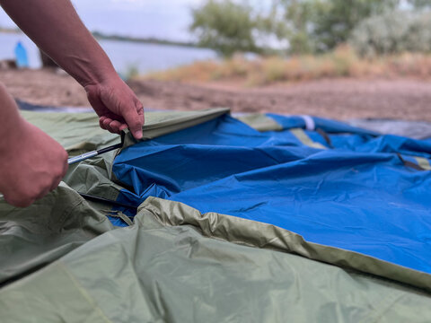 Person setting up a tent for outdoor camping