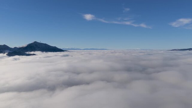 Left moving drone slide showcasing Trebevic above thick fog, ideal for tourism branding, cinematic travel edits and atmospheric winter landscape footage