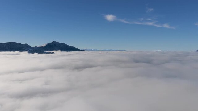 Smooth drone rise revealing Trebevic mountain above Sarajevo fog, perfect for tourism campaigns, inspirational travel visuals and clean-air themed winter footage