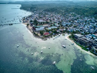 Aerial of General Luna coastline with boats over shallow reef, Siargao