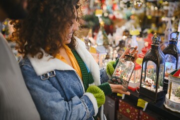 Woman shopping christmas market for snow globe lantern