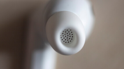 Close-up of circular perforated design on white earbuds