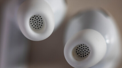 White earbuds: close-up of sound outlet perforations