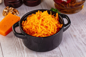 Yellow shredded cheddar cheese in the bowl