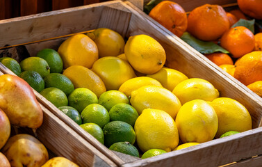Ripe natural lemons at the market. Farmers' market with fresh fruits and vegetables. Colorful display of seasonal produce for retail sale. Fruits and vegetables at the market.