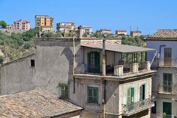 Rossano old town residential buildings with green shutters. Rossano buildings creating an urban landscape under a clear blue sky in southern Italy.
