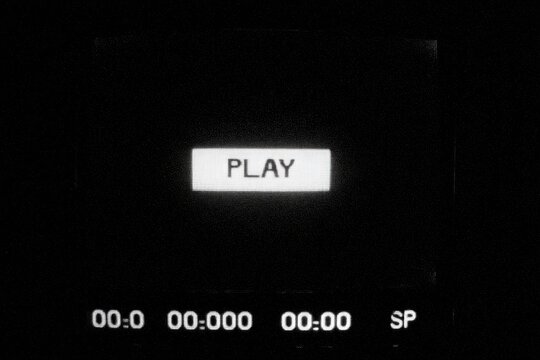 A black and white image features a "PLAY" button and a timer display at the bottom