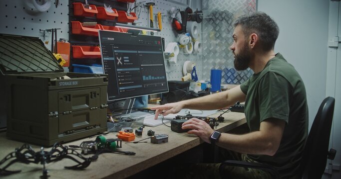 Engineer Combining Software Design With Physical Drone Assembly. Man Works Meticulously Organized Bench, Combining Software Design on Monitor With Physical Assembly Complex Drone. Technical Precision.