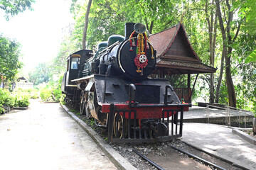 Old steam locomotive in the countryside. Front view of an antique locomotive that is part of a World War II memorial, when the Japanese army took prisoners of war to build the Death Railway