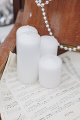 a closeup shot of a white four candlestick and a candle. Christmas decoration 