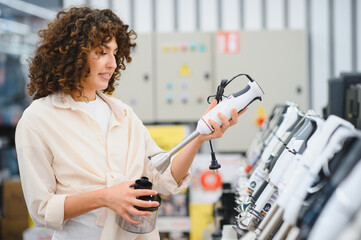 Woman choosing immersion blender in electronics store