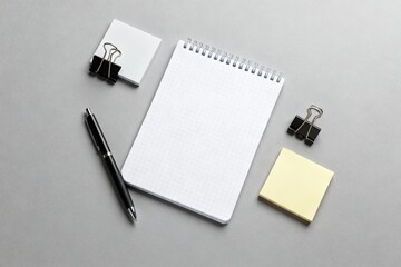 A minimal flatlay of office supplies arranged on a neutral gray background
