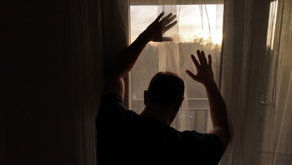 Silhouette of depressed, sad and lonely man in the apartment.