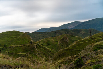 A beautiful mountain landscape with green hills and a cloudy sky