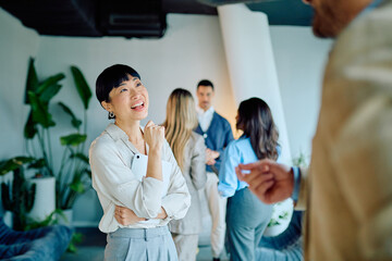 Diverse business professionals networking and engaging in discussion at an modern office, depicting collaboration and success