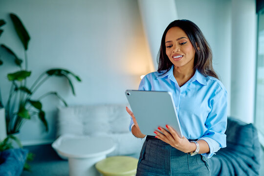 Professional businesswoman using a tablet in a contemporary workspace, engaging with technology for business communication and data analysis