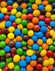 Obraz premium Colorful Candy Coated Chocolate Pieces Background Texture.