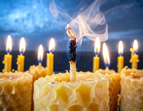 An array of burning and one smoking beeswax candles creating a warm and contemplative atmosphere - Powered by Adobe