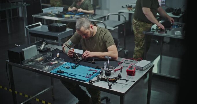 Technician Performing Intricate Repair and Maintenance of FPV Drone Electronics, Using Soldering Iron. Concept of Technical Service and Complexity of Drone Maintenance, Troubleshooting. Static Shot.