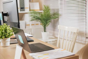 home office workspace features modern business desk, laptop computer, monitor setup, documents, green plants, creating productive environment for remote work, digital tasks, comfortable chairs