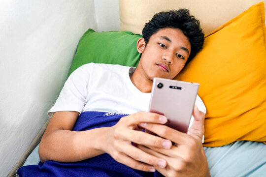 Teenager Relaxing In Bed With Smartphone, Scrolling Social Media In Bedroom