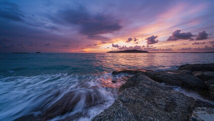 Obraz premium Sunset over ocean waves crashing against rocks, emphasizing natural erosion risk