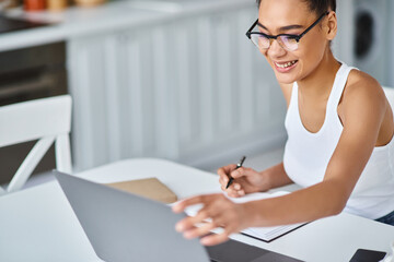 Young beautiful woman enjoying her cozy home office while working and creating