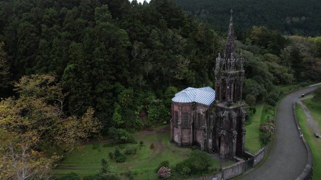 Capela de Nossa Senhora das Victorias shown in a closer aerial while drone circles from left to right near Furnas on Sao Miguel island in the Azores