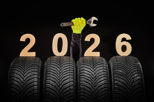 Winter car tires service and thumbs up hands of mechanic and text 2026 happy new year on black background - Powered by Adobe