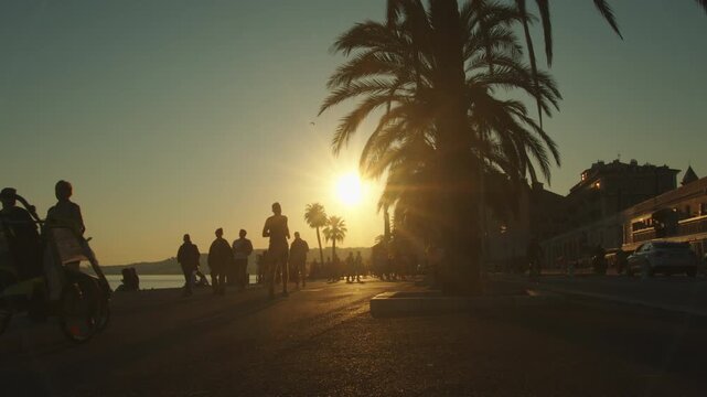 4K French Riviera Nice silhouettes of people running and walking on the seaside at sunset slow motion
