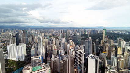 Obraz premium Stunning aerial panorama of Makati City in Metro Manila, Philippines, showing a dense cluster of modern skyscrapers and high-rise towers.