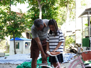 Father and Daughter Repairing a Bicycle Together, Learning Practical Skills.
