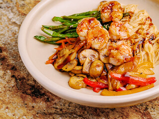 Delicious shrimp stir-fry with vegetables and noodles on a plate