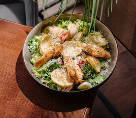 Fresh salad with crispy chicken and vegetables on a wooden table