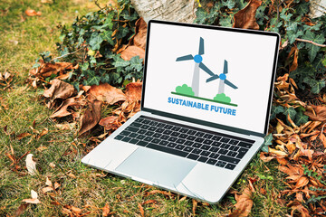 Laptop displaying sustainable future wind energy concept in nature