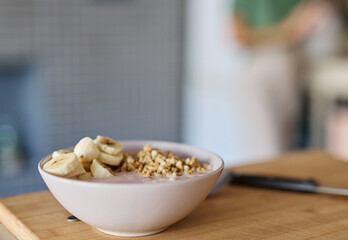 Portrait of a young woman preparing and eating breakfast, drinking juice in the kitchen at home