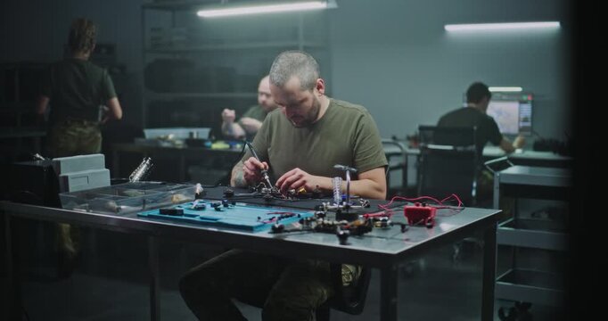 Man Assembling High Speed FPV Drone For Professional Use. Man Intensely Focused on Assembling High Speed FPV Drone, Working on Internal Wiring and Frame. Concept of Growing Field of FPV Technology.
