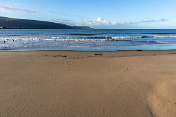 Gentle waves roll toward the sandy shoreline