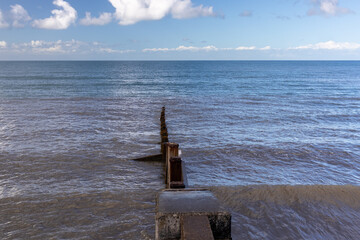 Concrete and timber coastal groyne extending into the water