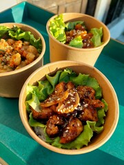 three bowls of rice with side dishes of chicken katsu with sweet and spicy taste and lettuce