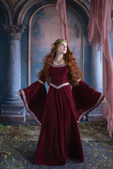 A girl in an elf costume in a studio with fabrics. Medieval decorations