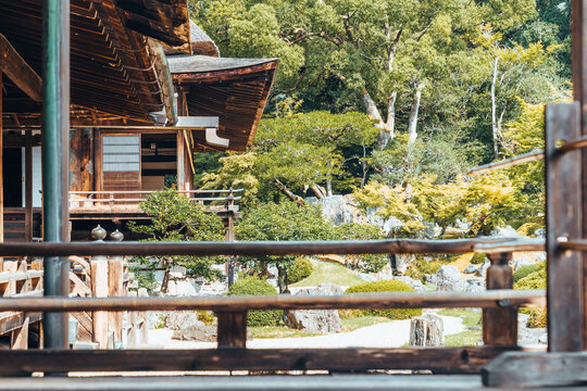 A traditional Japanese building with a wooden balcony overlooking a serene garden