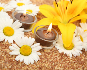 Yellow lily and burning candles