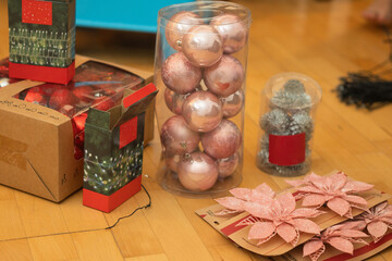 Christmas decorations, ornaments, and poinsettia flowers on wooden floor