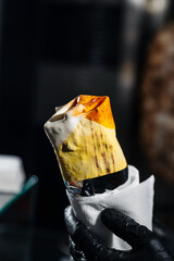 A ready shawarma wrap held in a person’s hand
