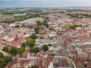 Naklejka premium Salisbury UK: 27th July 2025: Drone aerial view showcases Salisbury's charming streets and the lush green countryside in the background, highlighting England's picturesque scenery
