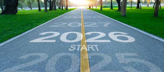 Fototapeta premium 2026 written on the road in the middle of the asphalt at sunset, with the start of 2026 on the runway. Planning concepts and challenges or career paths, business strategies, opportunities and change.